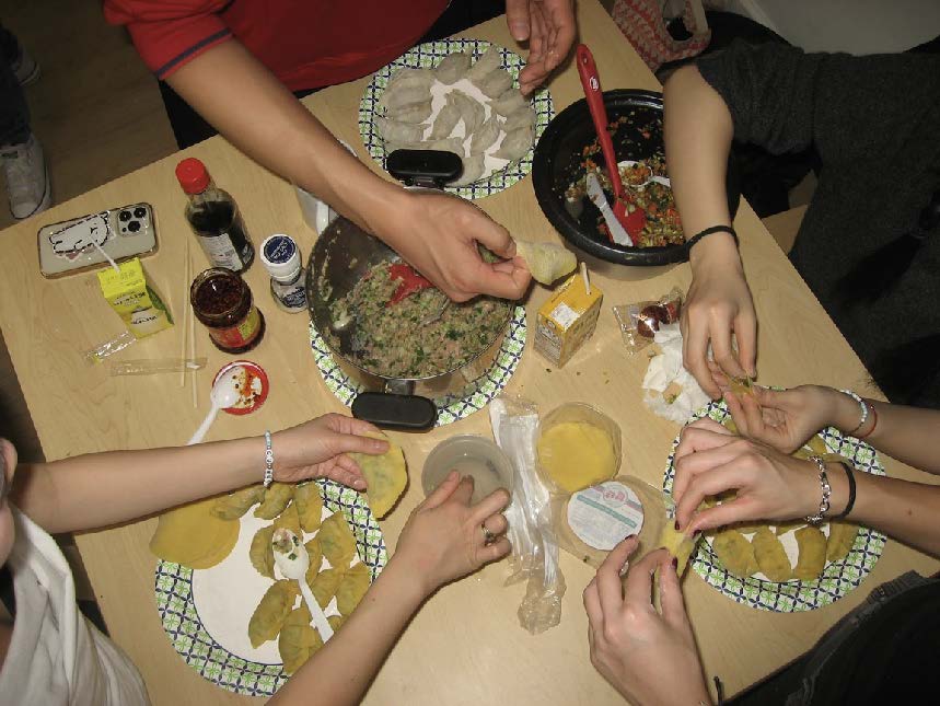 Members folding dumplings
